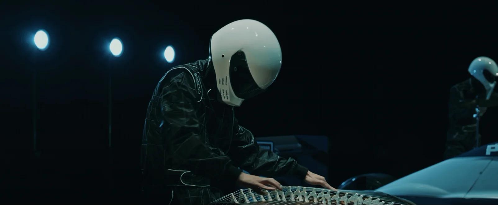 ヘルメット姿で箏を演奏するシーン
