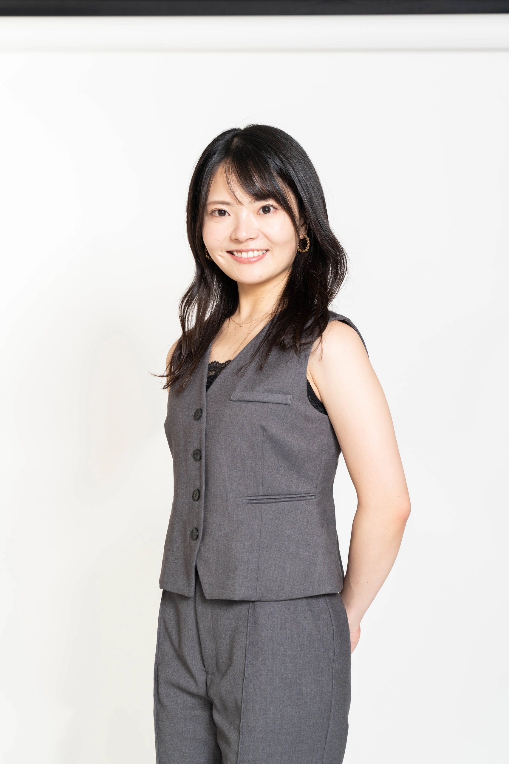 グレーの衣装で穏やかな笑顔を見せる人物