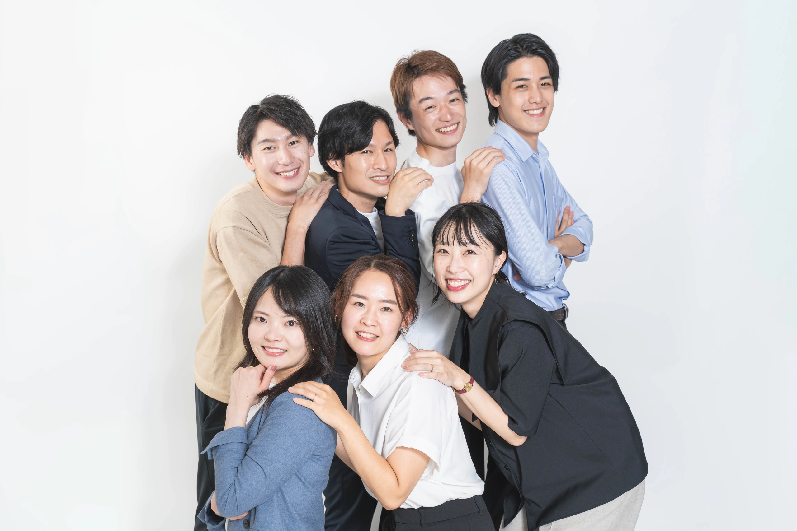 前後に並んだメンバーが笑顔を見せる集合写真